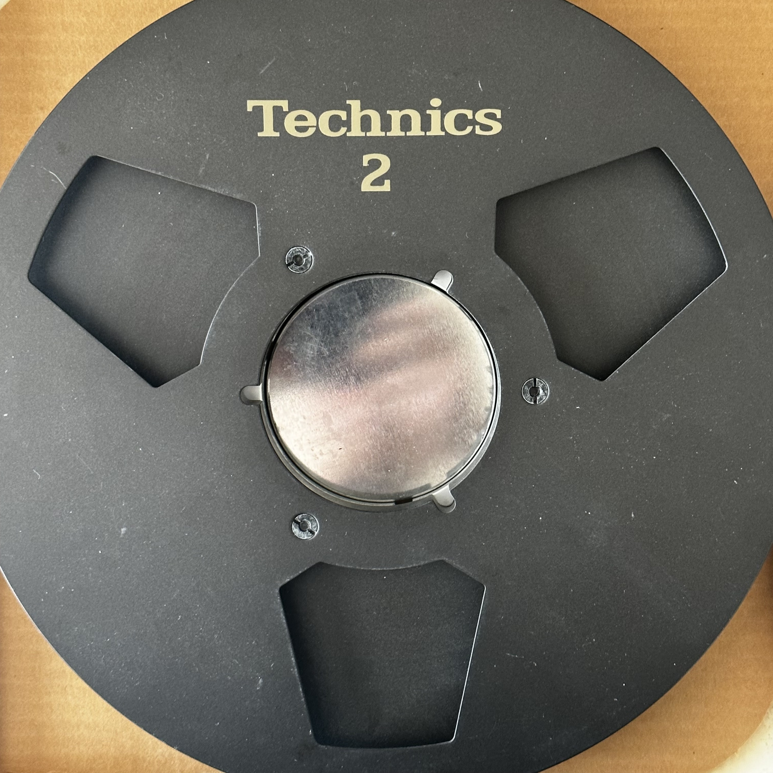 thumbnail interactive-video image 1 of Ampex 10" Empty Metal Tape Reel - 1/4", Classic 3-Window Silver Design With Box 1 of 13